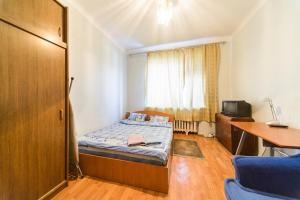 een kleine slaapkamer met een bed en een bureau bij Квартира по адресу ул. Черняховского 12 in Kiev
