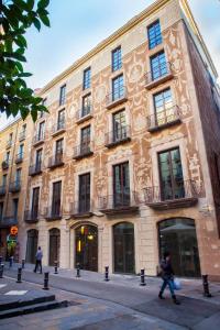 un gran edificio con gente caminando delante de él en Aparthotel Arai 4* Superior, en Barcelona