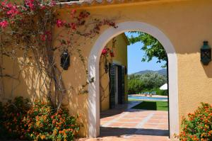 an archway leading into a yard with flowers at Finca Son Blat in Porto Cristo