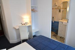 a small room with a bed and a bathroom at Le Renaissance in Aurillac