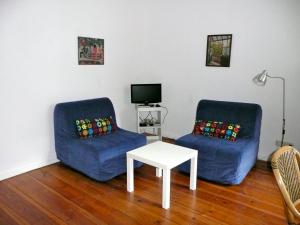 ein Wohnzimmer mit 2 blauen Sofas und einem Tisch in der Unterkunft City Apartment Berlin in Berlin