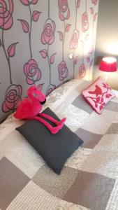 a pink teddy bear laying on a bed at les maisons blanches in Weris