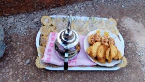 a plate of food with cookies and wine glasses at Gite Du Lac in Ouirgane