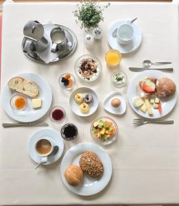 una mesa con platos de comida y tazas de café en Hotel Quellenhof, en Naturno