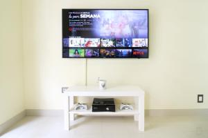 a white table with a tv on a wall at Heart of Sitges in Sitges