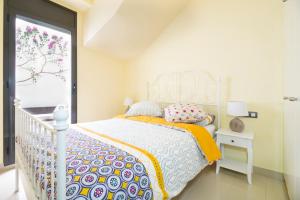 a white bedroom with a bed and a window at Heart of Sitges in Sitges