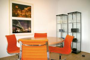uma sala de jantar com uma mesa e cadeiras laranja em Premium Apartment Universities/Arts District em Munique