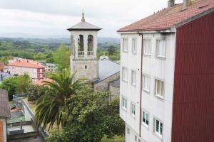 a building with a clock tower in a city at Hotel Mica in Palas de Rei