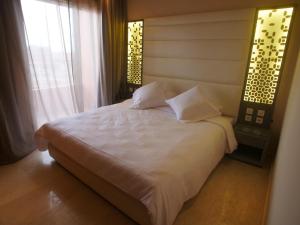 马拉喀什Jnane Gueliz的一间卧室，有一张白色的床和一扇窗户 更多41张照片