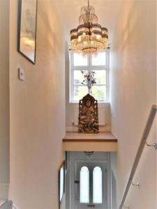 a chandelier hangs above a staircase with a window at Riverside Bed & Breakfast in Ironbridge