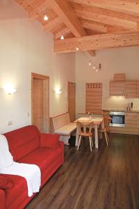 a living room with a red couch and a table at Appartements Stockinger in Grossarl