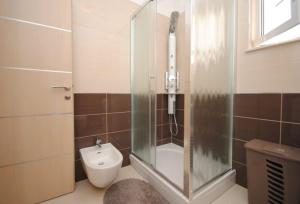 a bathroom with a glass shower and a toilet at Villa Guliver in Slatine +77 photos