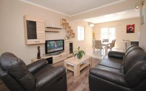 a living room with two leather couches and a television at Villa Guliver in Slatine