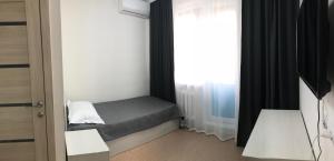 a small bedroom with a bed and a window at Prospect in Astana