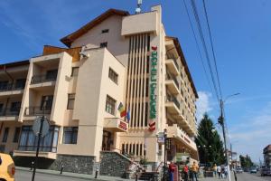 a building with people standing outside of it at Hotel Ciucas in Vălenii de Munte