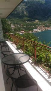 a table and chairs on a balcony overlooking the water at Apartment Angelina in Risan