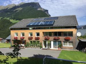 una casa con pannelli solari sul tetto di Gästehaus Pfandl ad Au im Bregenzerwald