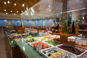 una línea de buffet con comida y botellas de vino en Hunguest Hotel Pelion en Tapolca