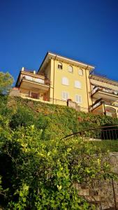 a building on top of a hill with bushes at Bellavista Eremitaggio in Torri del Benaco