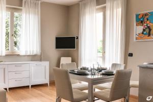 una sala da pranzo con tavolo, sedie e TV di 2-bedroom apt, with balcony & aircondition - 50 m from the beach a Marina di Pietrasanta