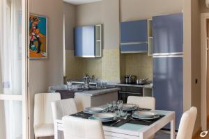 una cucina con tavolo, sedie e frigorifero di 2-bedroom apt, with balcony & aircondition - 50 m from the beach a Marina di Pietrasanta