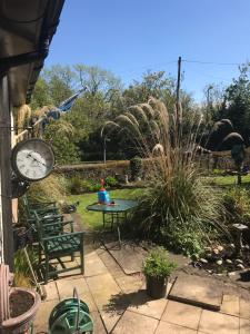 a patio with a clock and a table and chairs at Arron House in Hamilton +4 photos