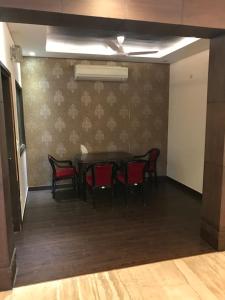 Spacious 3bhk apartment! في نيودلهي: غرفة طعام مع طاولة وكراسي حمراء