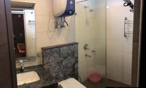ein Bad mit einer Dusche, einem Waschbecken und einem WC in der Unterkunft Spacious 3bhk apartment! in Neu-Delhi