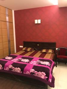 2 Betten in einem Zimmer mit roten Wänden in der Unterkunft Spacious 3bhk apartment! in Neu-Delhi