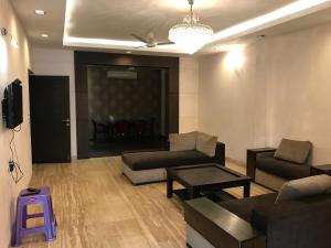 ein Wohnzimmer mit einem Sofa und einem Tisch in der Unterkunft Spacious 3bhk apartment! in Neu-Delhi