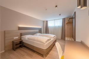 Dormitorio pequeño con cama y mesa en Vineus Tramin, en Termeno