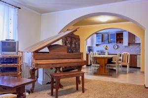 a living room with a piano and a kitchen at King Arthur Panzió in Baja
