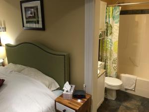 a bedroom with a bed and a toilet and a table at Robert Porter House Inn in Victoria +92 photos