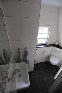 baño con lavabo y aseo y ventana en Winzerschenke en Beilstein