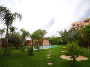 马拉喀什Jnane Gueliz的一个带游泳池和棕榈树的庭院