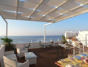 ein Balkon mit Tischen und Stühlen und dem Meer in der Unterkunft B&B Finestra Sul Mare in Gallipoli