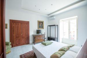 a bedroom with a bed and a tv and a window at Palazzo Doria d'Angri Suites in Naples