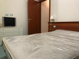 a bedroom with a bed and a flat screen tv at Joseph Apartment in San Benedetto del Tronto