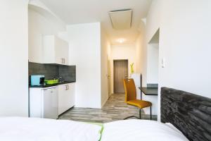 a bedroom with a bed and a desk and a kitchen at Allram "TopSleep" 24 hours checkin in Waidhofen an der Thaya
