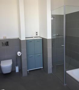 a bathroom with a toilet and a glass shower at Anker Guest House in Bielefeld