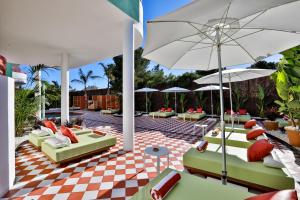un patio con sillas y sombrillas en un suelo a cuadros en Cubanito Ibiza, en San Antonio