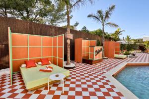 un patio con piscina y una mesa junto a un complejo en Cubanito Ibiza, en San Antonio