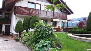 een huis met een balkon en een tuin bij Apartments Magdalena in Radovljica