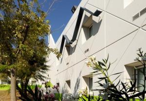 a white building with windows on the side of it at Lemon Hôtel Avignon Rochefort in Rochefort-du-Gard