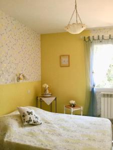 sypialnia z łóżkiem i żółtą ścianą w obiekcie La Vigne Des Heures Claires w mieście Saint-Nazaire-dʼAude