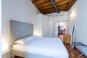 a bedroom with a large white bed and wooden ceilings at Brera 20 in Milan