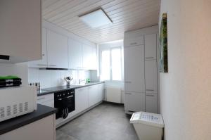 a white kitchen with white cabinets and a window at Interlaken Central 1 in Interlaken