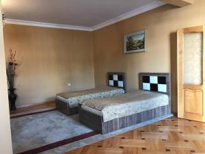 2 camas en una habitación con suelo de madera en Guest House kartvelishvili en Batumi