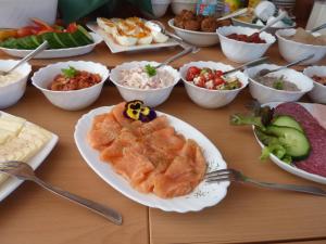 a table with plates of food and bowls of different foods at Spreewald Pension Spreeaue in Burg +42 photos