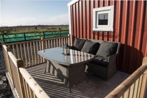 a patio with a table and a couch on a deck at The Wild Atlantic Way Barn in Oranmore